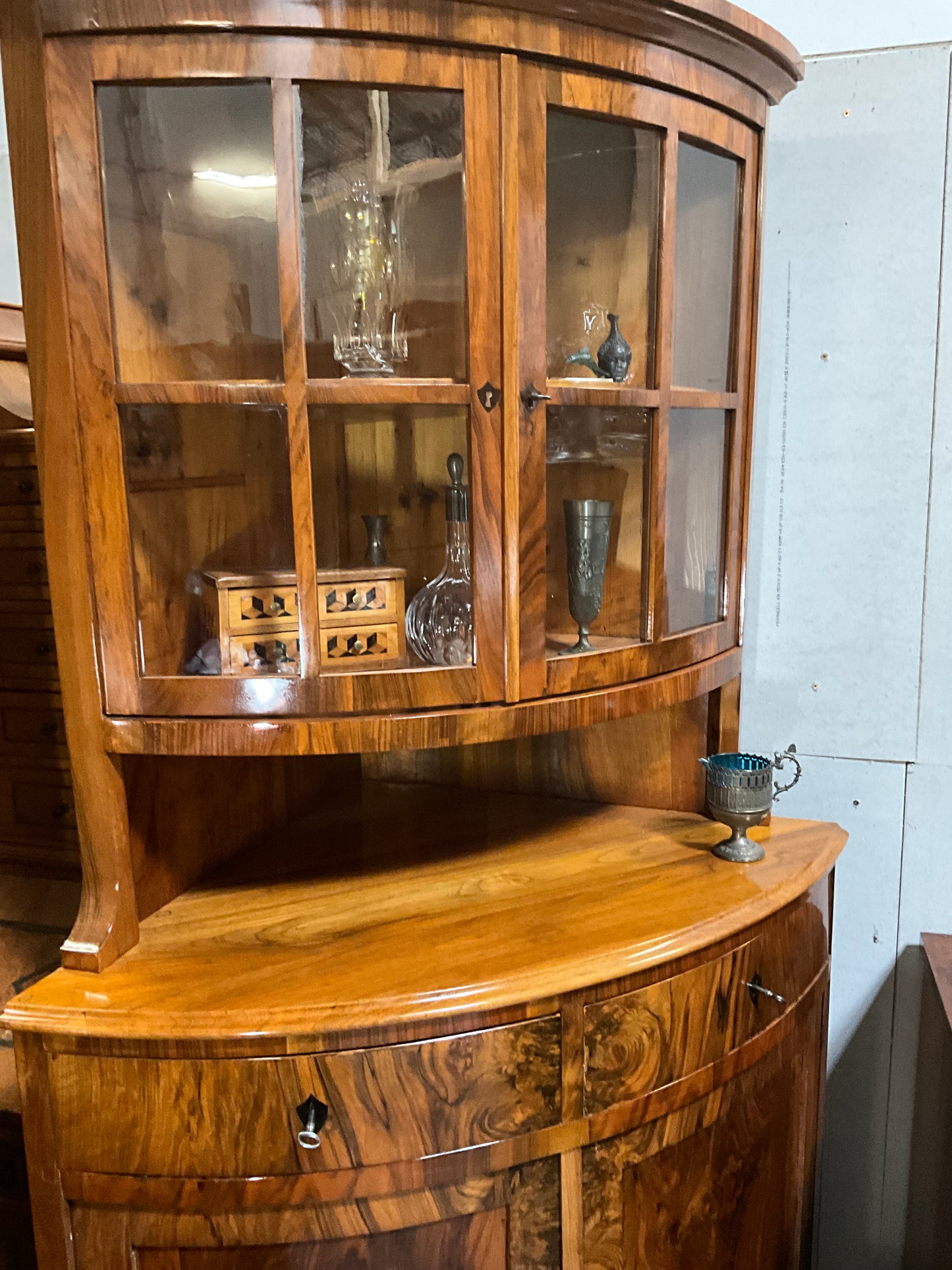 Seltene Biedermeiereckvitrine in Nussbaum um 1820