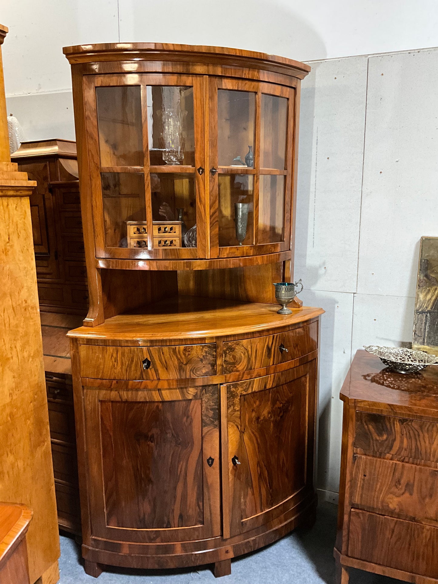 Seltene Biedermeiereckvitrine in Nussbaum um 1820