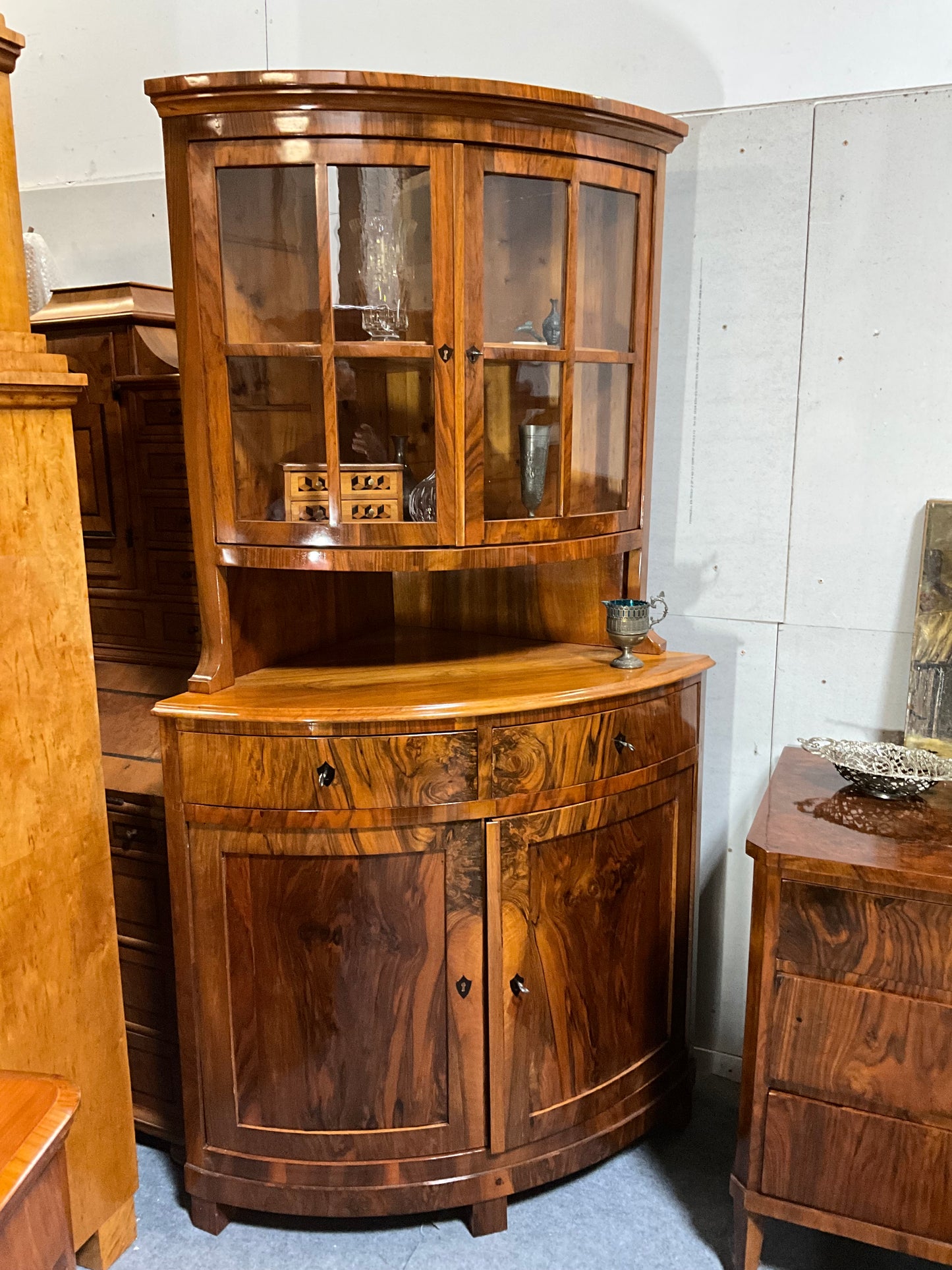 Seltene Biedermeiereckvitrine in Nussbaum um 1820