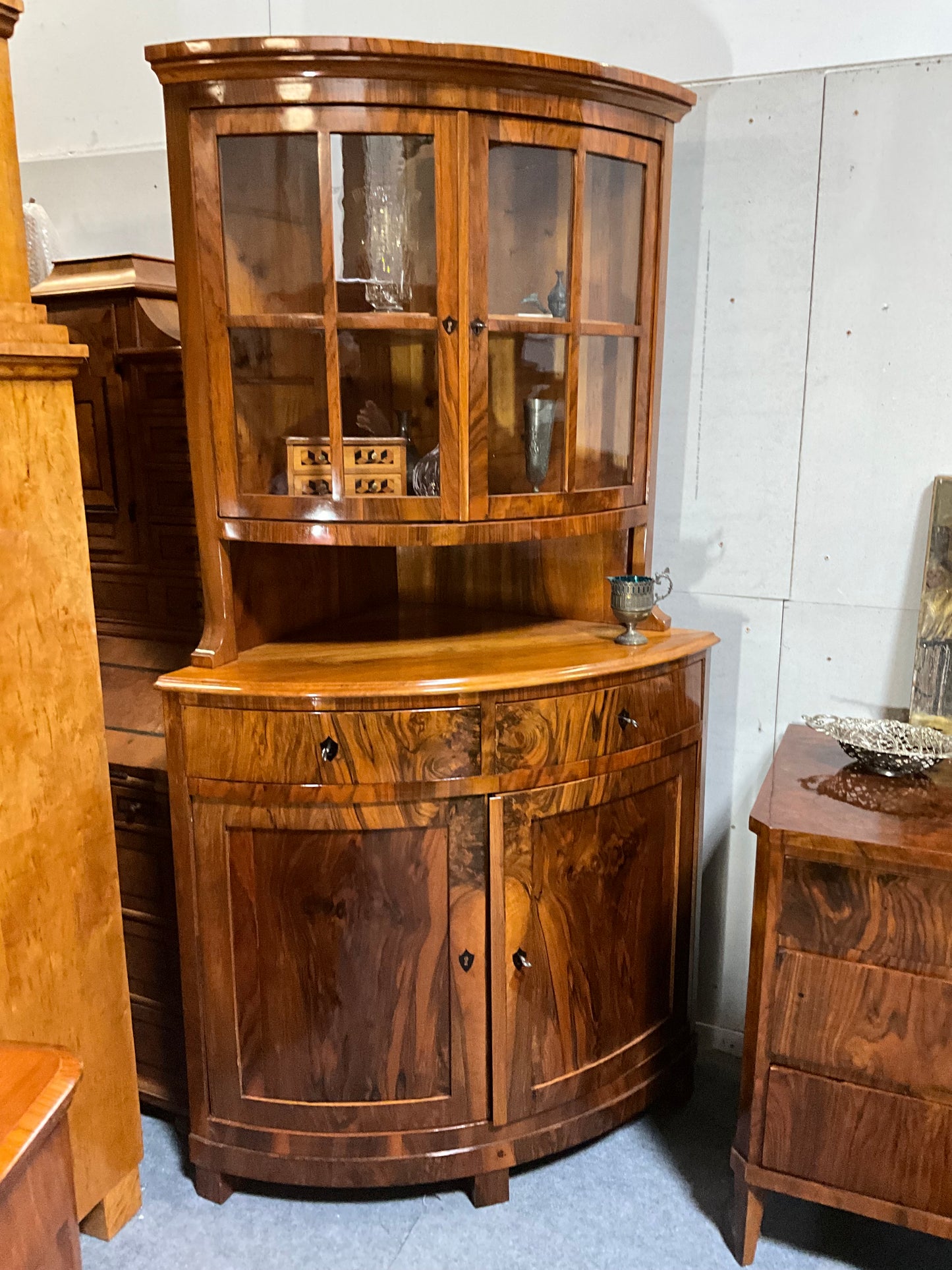 Seltene Biedermeiereckvitrine in Nussbaum um 1820