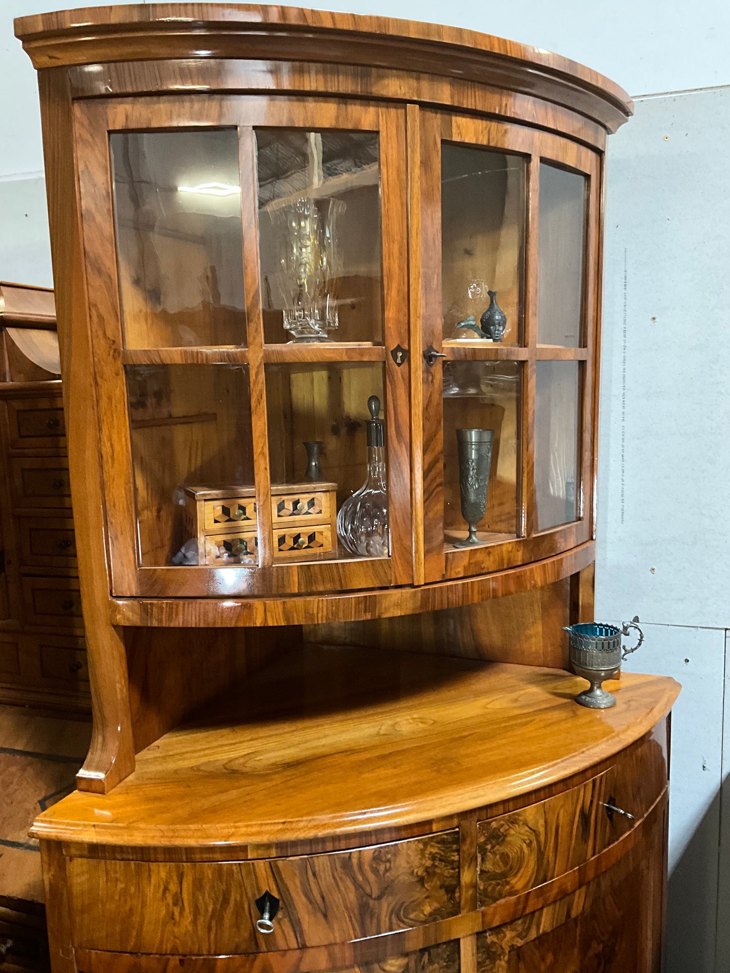 Seltene Biedermeiereckvitrine in Nussbaum um 1820