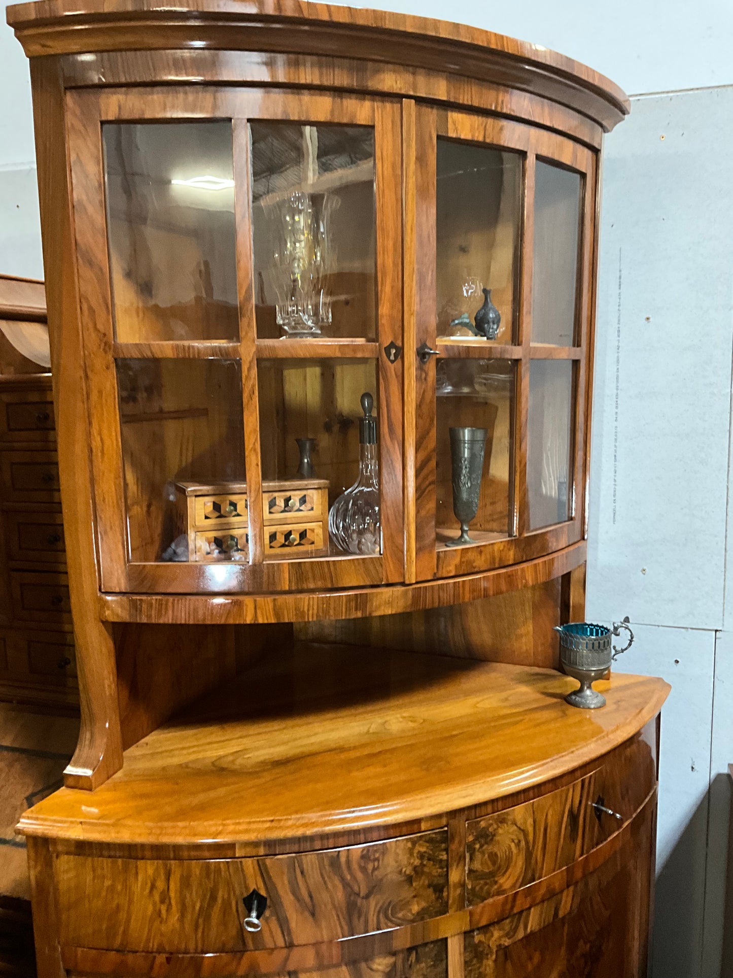 Seltene Biedermeiereckvitrine in Nussbaum um 1820