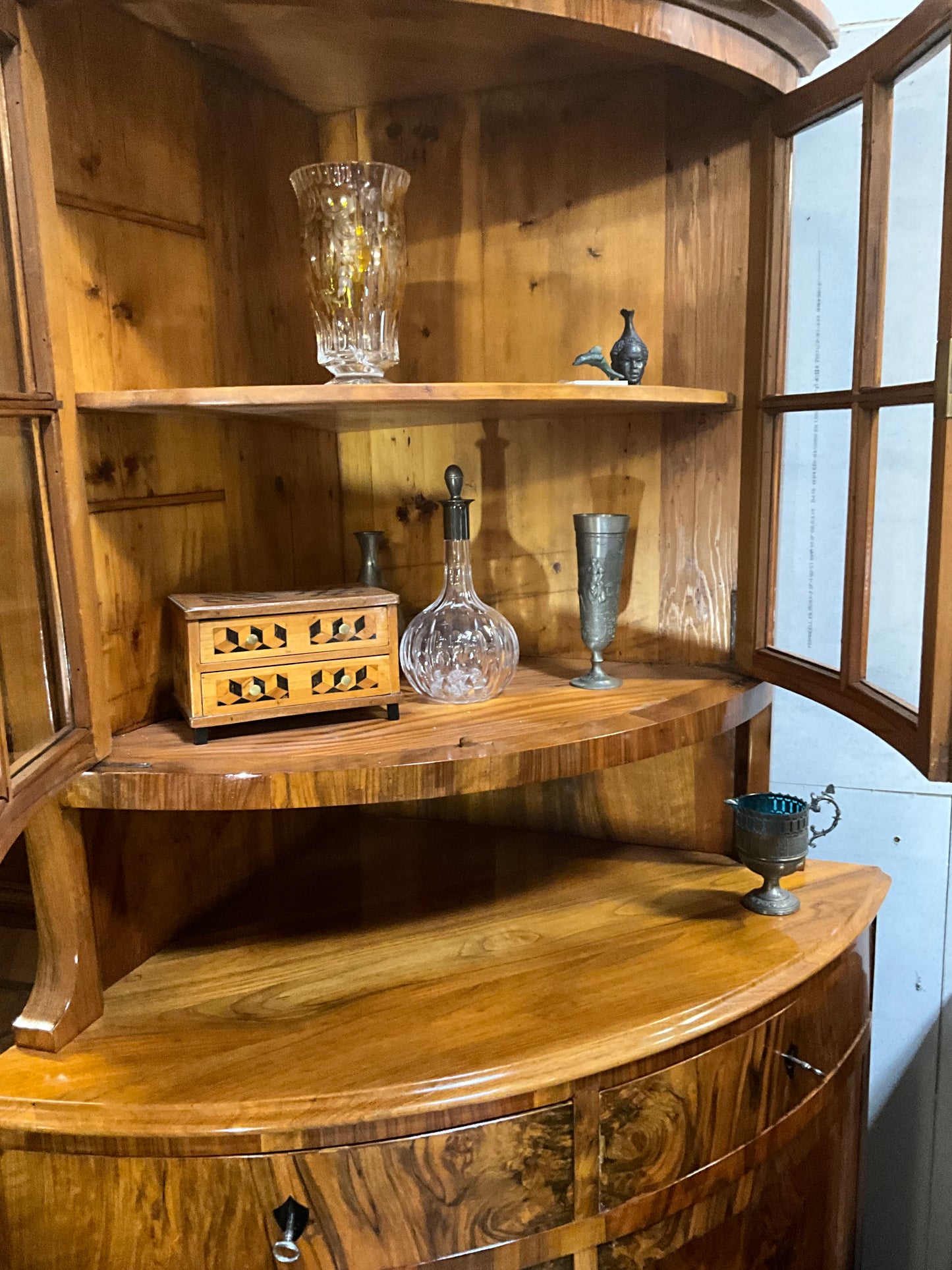 Seltene Biedermeiereckvitrine in Nussbaum um 1820