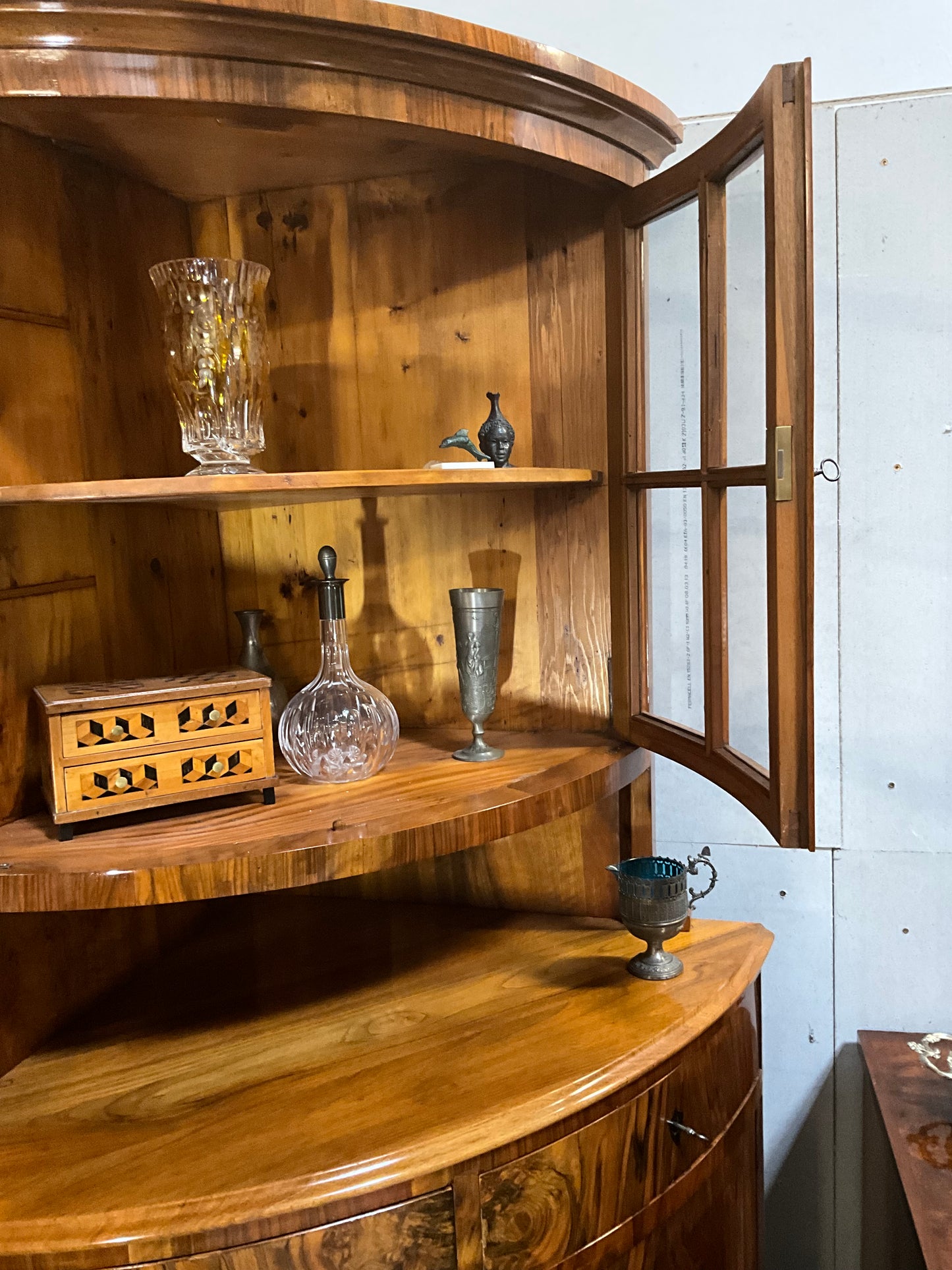 Seltene Biedermeiereckvitrine in Nussbaum um 1820