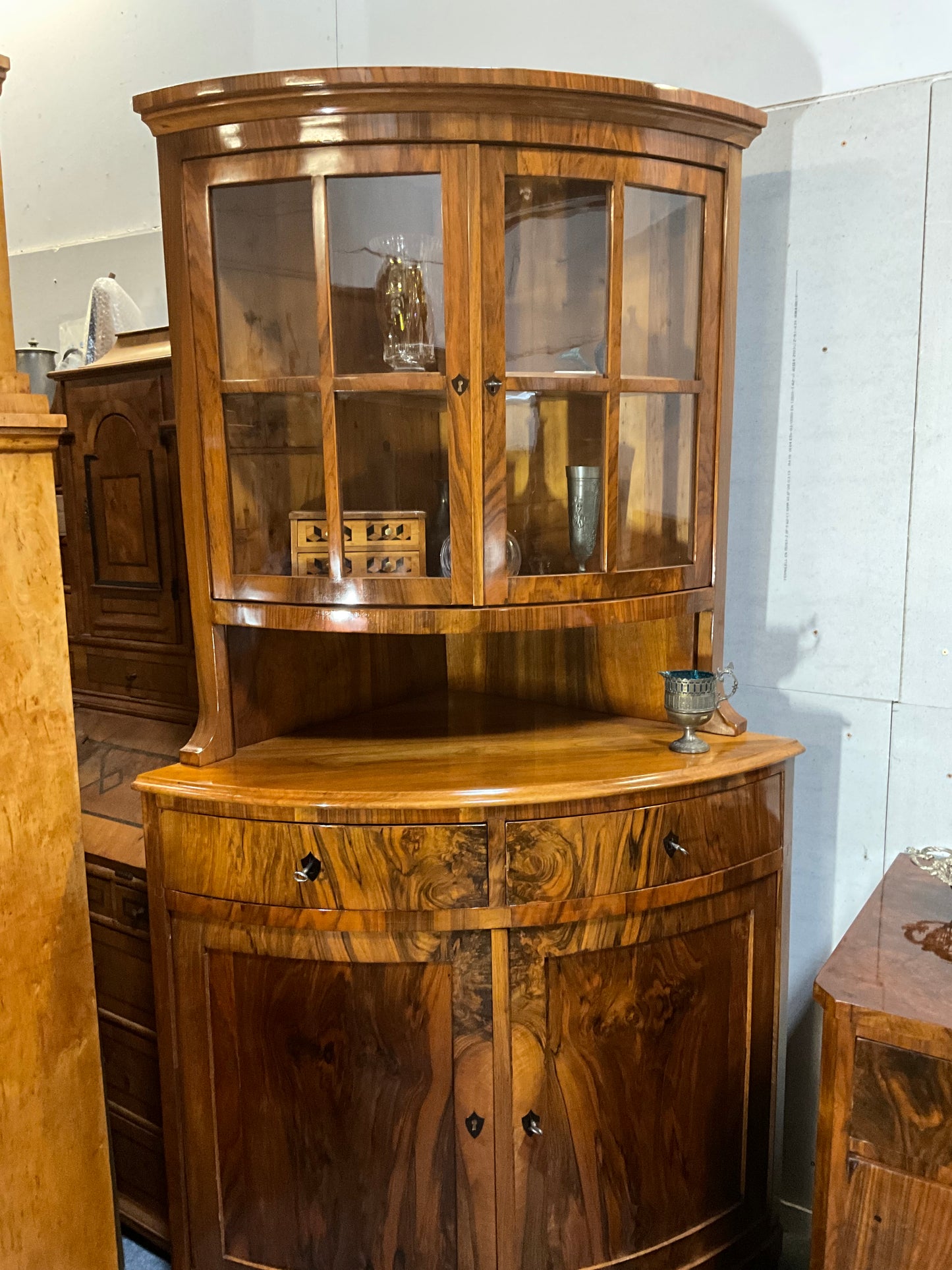 Seltene Biedermeiereckvitrine in Nussbaum um 1820