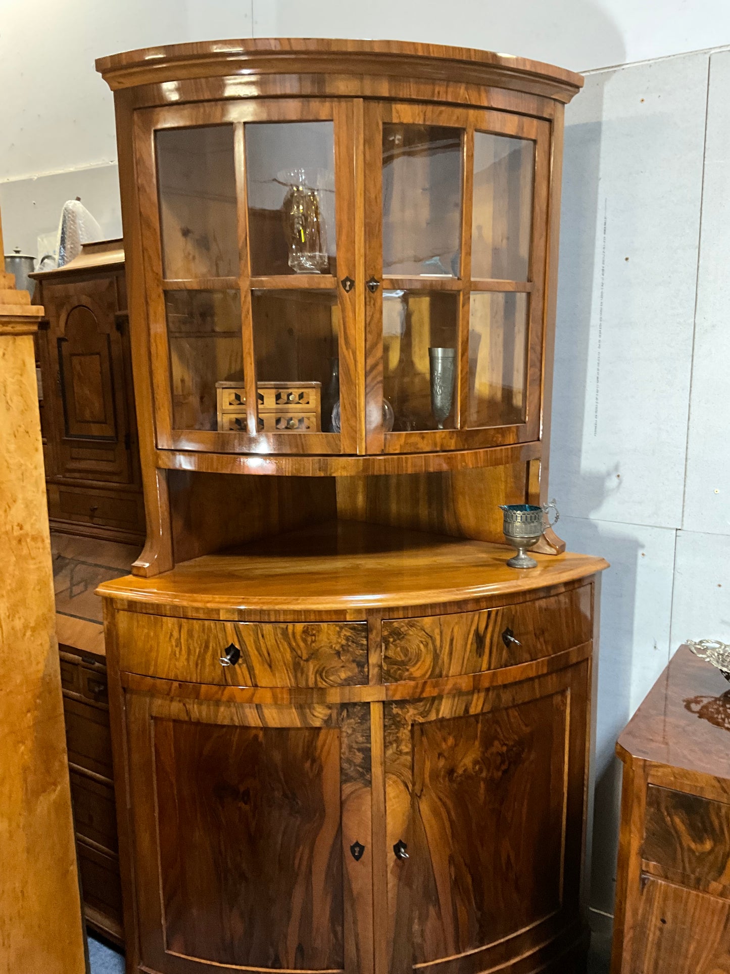 Seltene Biedermeiereckvitrine in Nussbaum um 1820