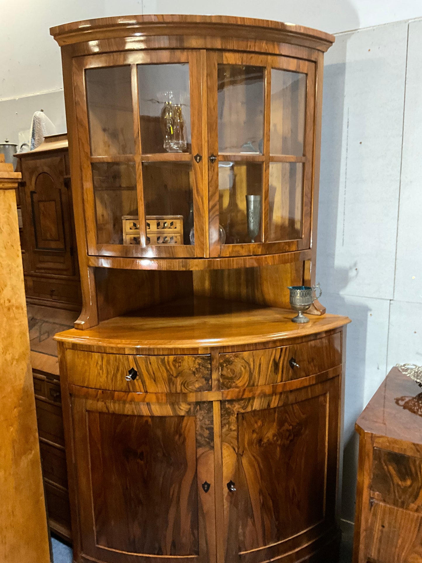 Seltene Biedermeiereckvitrine in Nussbaum um 1820